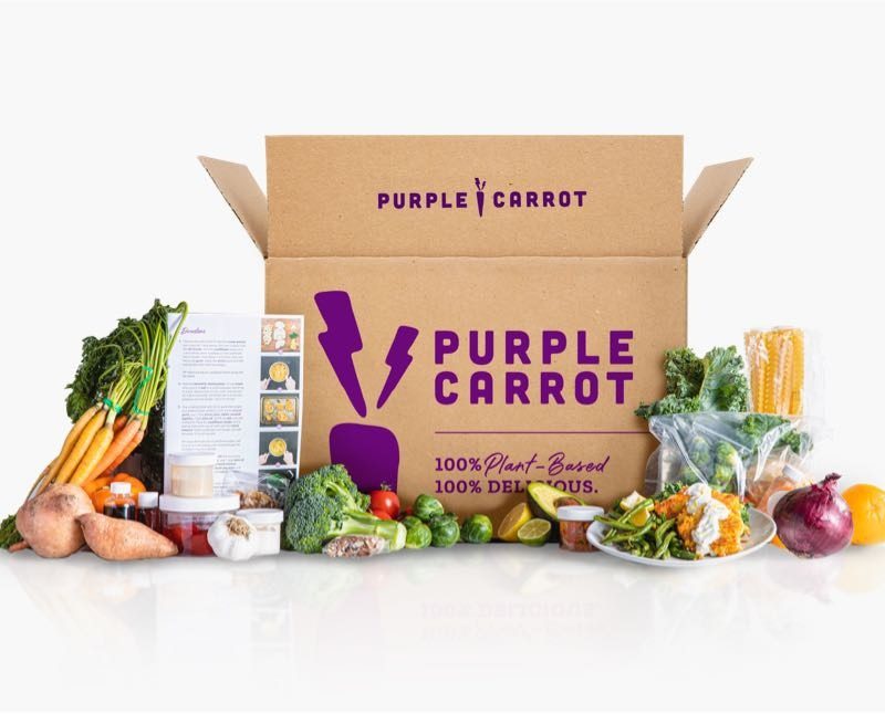 Healthy foods and a Purple Carrot box on a white surface.