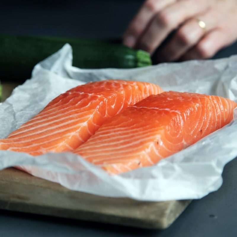 Two salmon filets sitting on butcher paper.