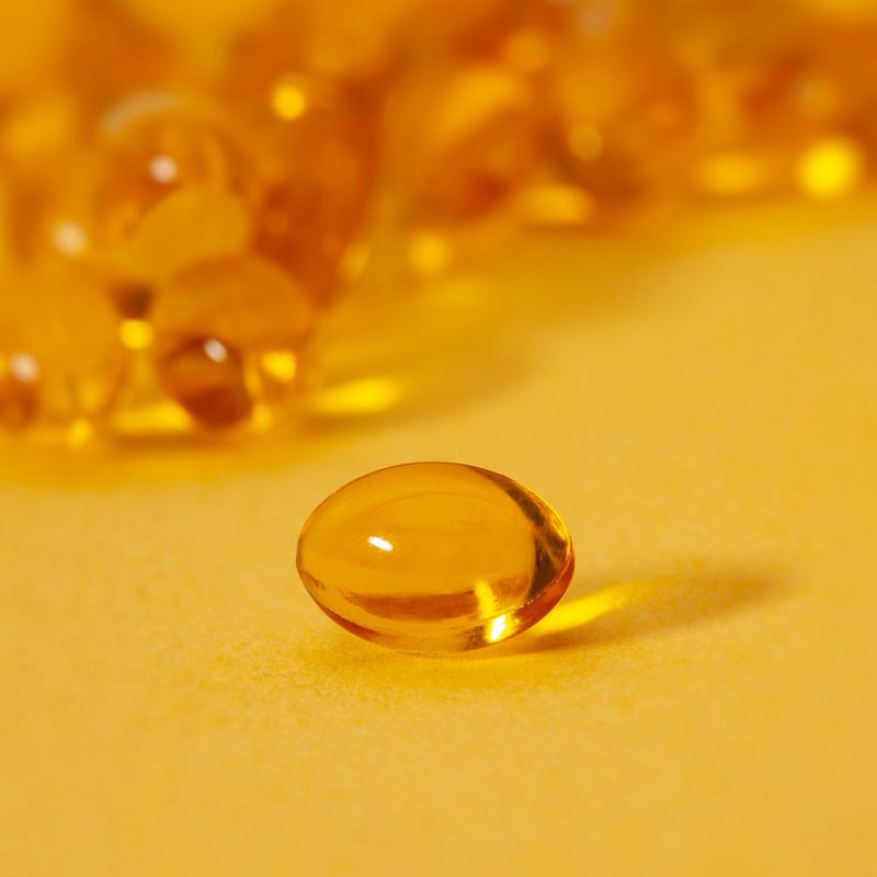 A close-up of a vitamin D capsule