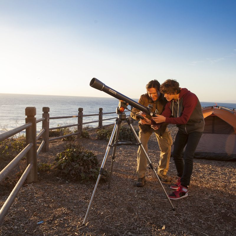 Two people camping and using their Celestron Telescope.