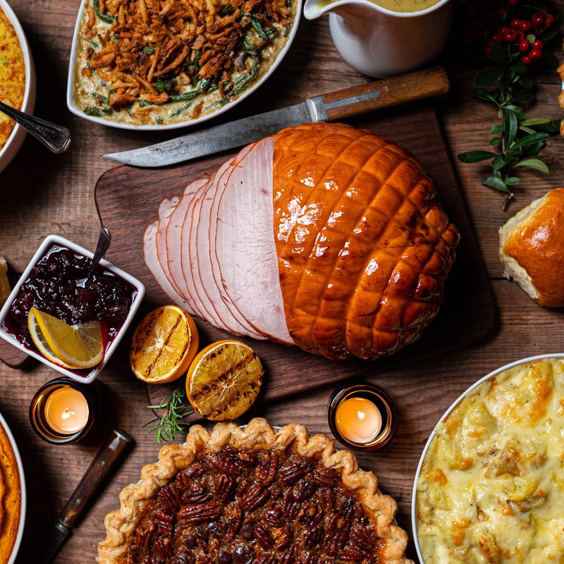 Thanksgiving meal with turkey breast, pies and casseroles on a table.