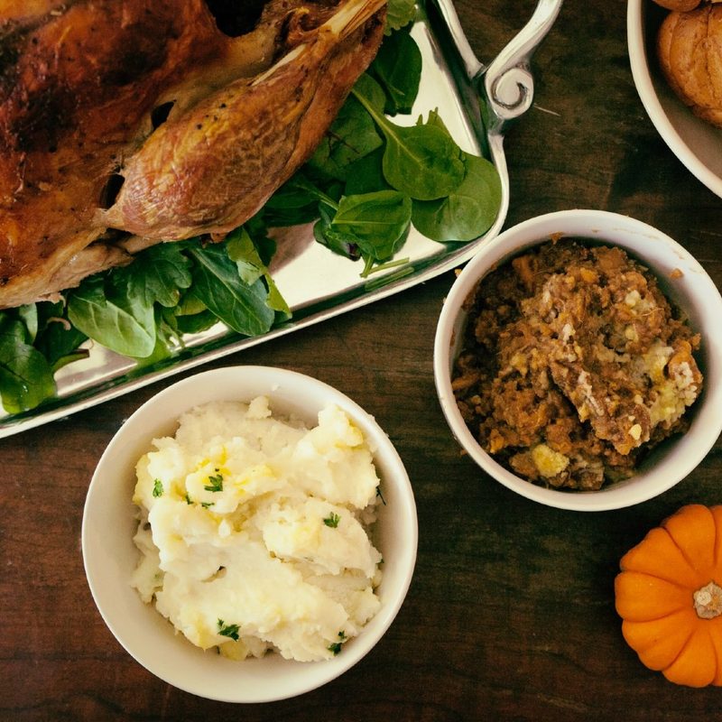 thanksgiving side dishes sitting next to a roasted turkey on a platter.