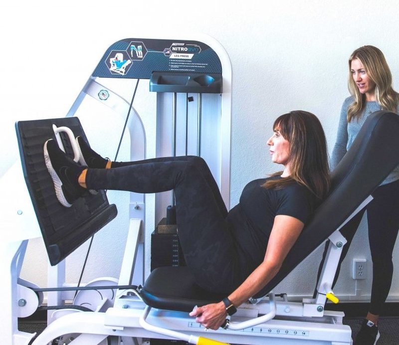 The Perfect Workout virtual training with woman doing leg exercises on machine.