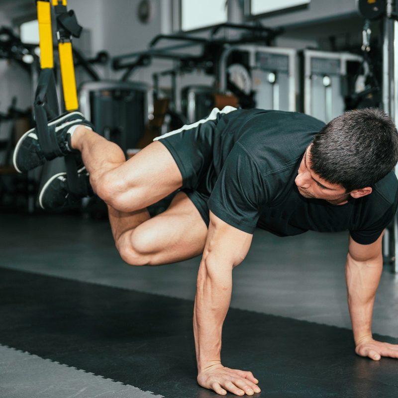 Man doing torso rotation push ups at the gym.