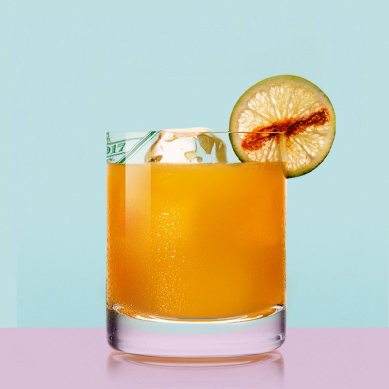 A refreshing glass of Tigre de Valle cocktail with garnish on blue background.