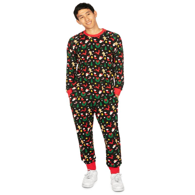 A model wearing a Tipsy Elves Men's Cookie Cutter Pajama Set and white sneakers.