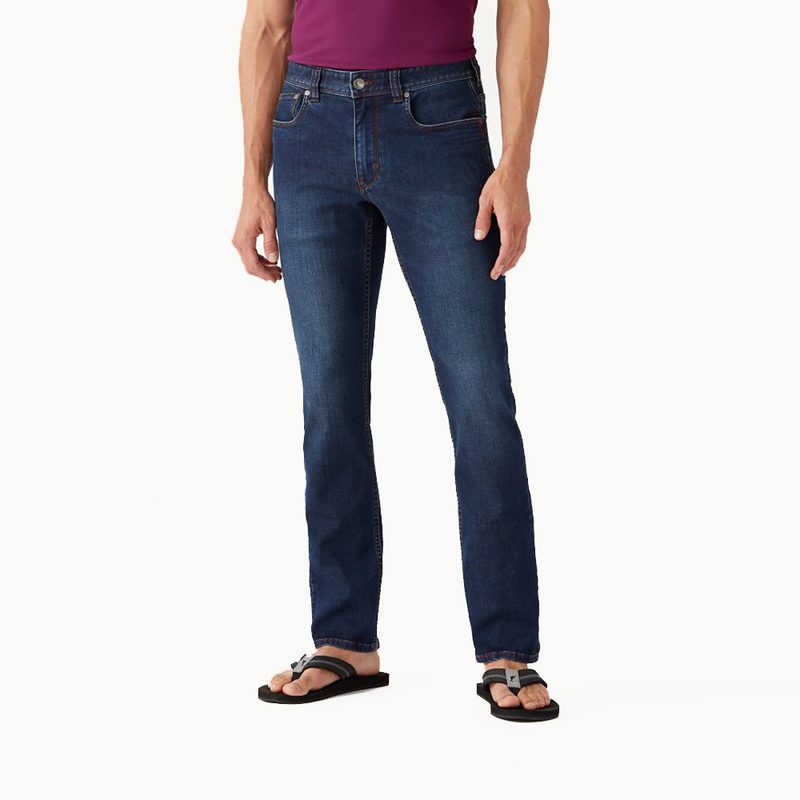 A male model wearing Tommy Bahama Boracay Jeans and slippers.