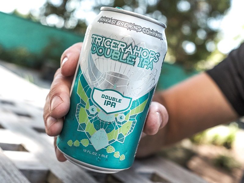 Man holding a Ninkasi Tricerahops Double IPA.