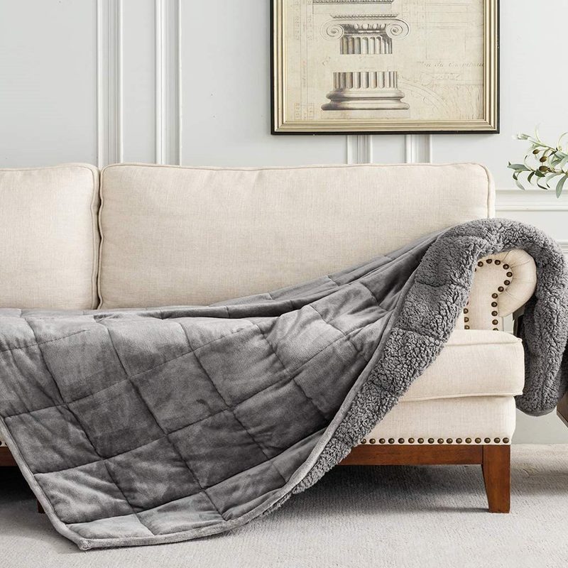 A Uttermara Sherpa Fleece Weighted Blanket on a couch in a living room.