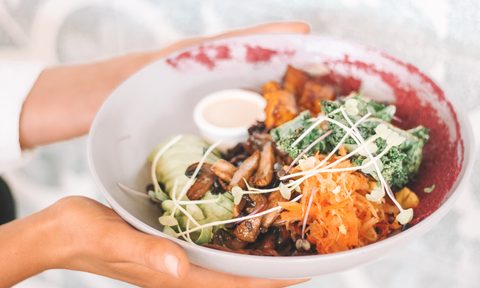 A person holding a vegan bowl.