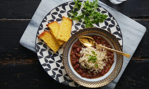 Bowl of Vegan Red Beans & Rice with Cornbread slices on a table.