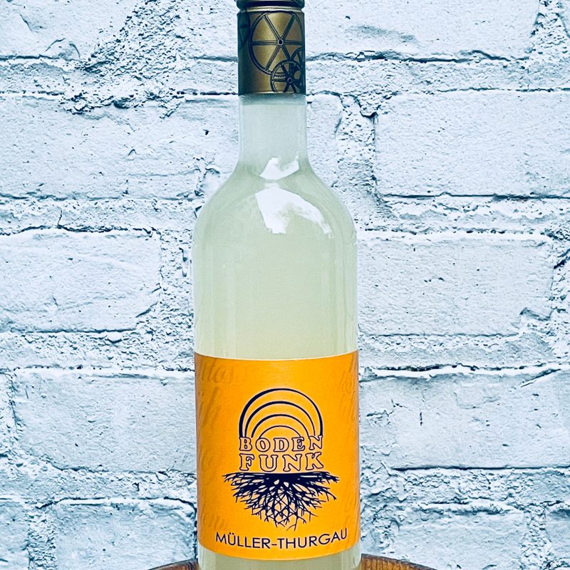 Bottle of Weingut Schlossmuhlenhof, 'Müller-Thurgau Boden Funk,' Rheinhessen, Germany 2020 against a wall.