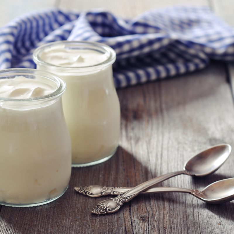 Two spoons and two jars of yogurt.