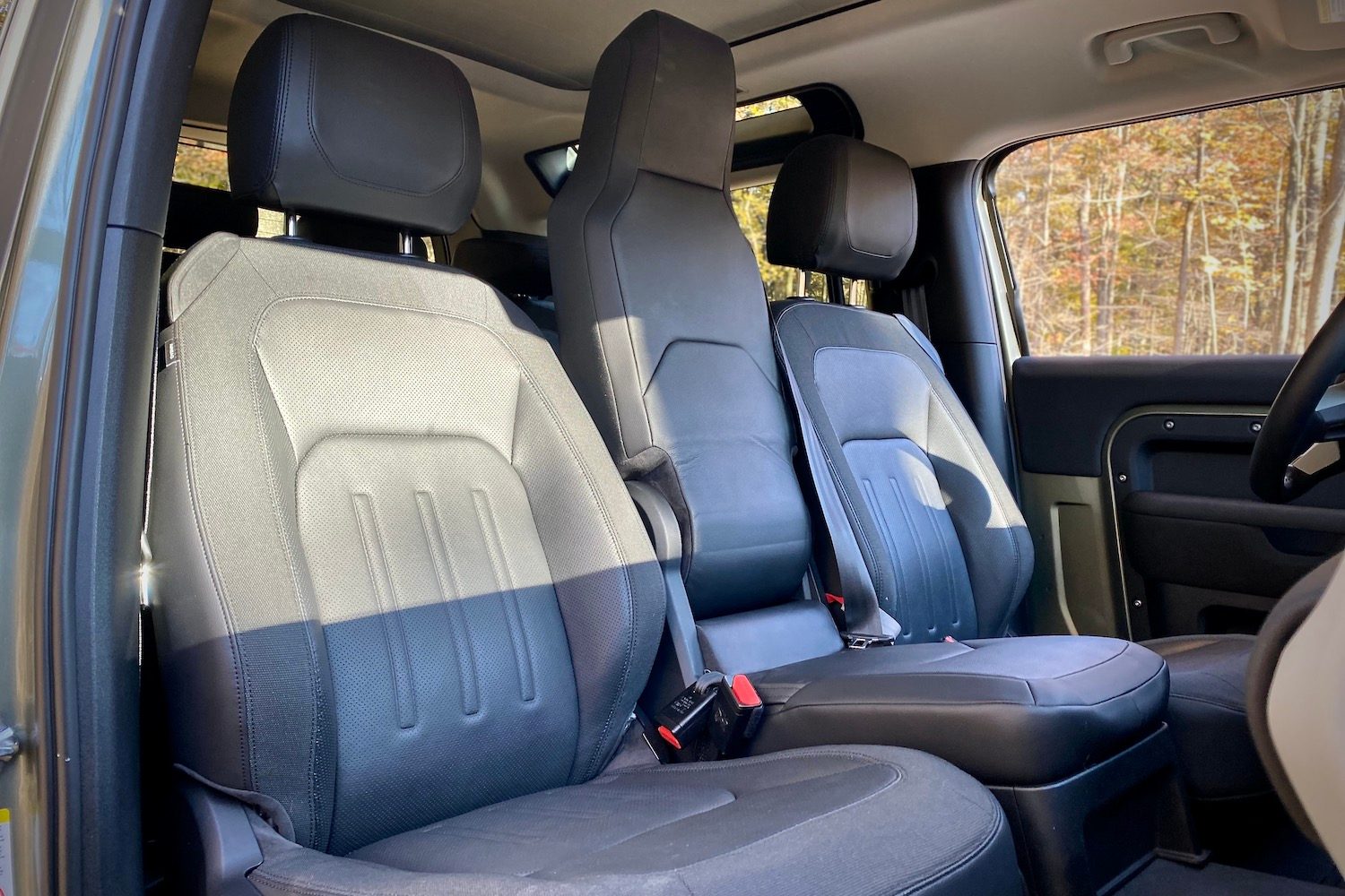 Front seats in Land Rover Defender from passenger's side.