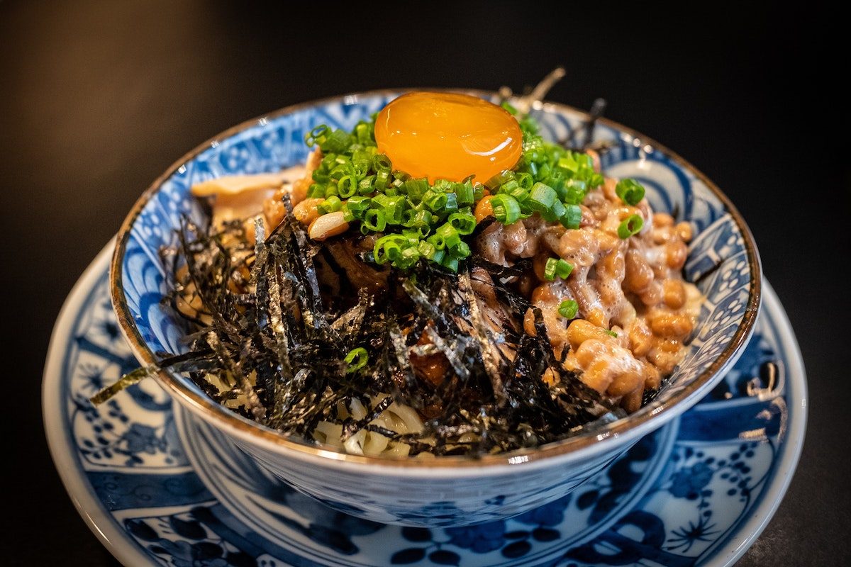 A Bowl of natto sitting on a plate