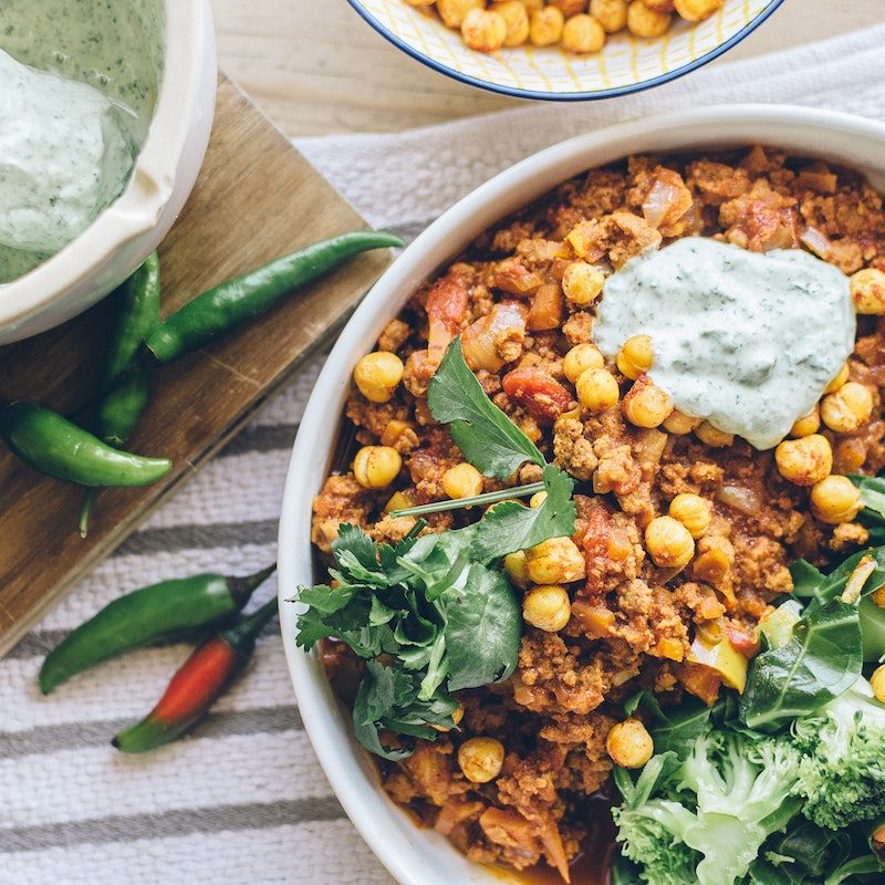 Lentil dish on a kitchen table surrounded by other food.