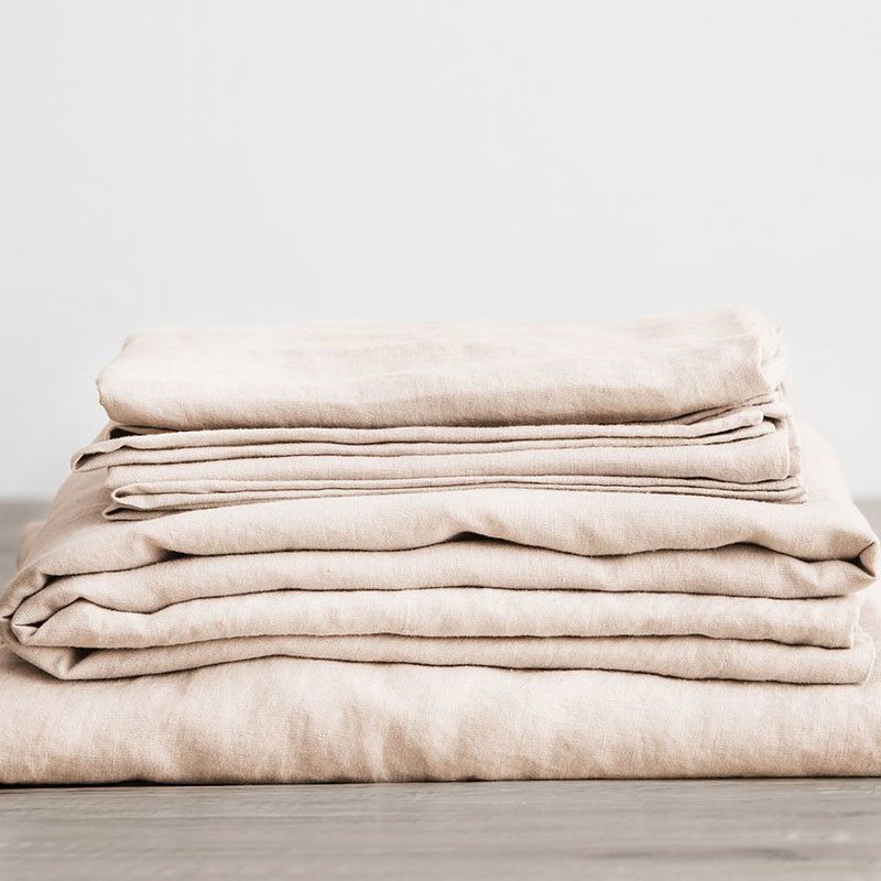 A close-up of Cultiver Linen Sheets folded neatly on the floor.