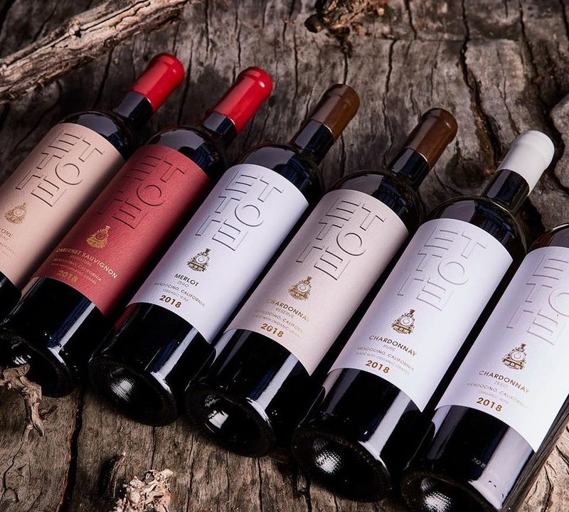 Selection of ETTORE Wine bottles on wooden table.