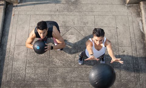 Future coach and trainee working out with medicine balls.