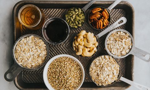 nuts, oats, oils, and various gluten free food on a tray.