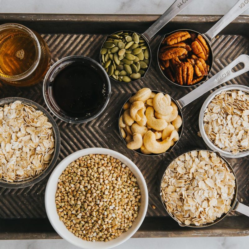 nuts, oats, oils, and various gluten free food on a tray.