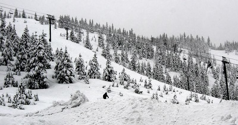 view of a snow covered mountain side with a ski lift.