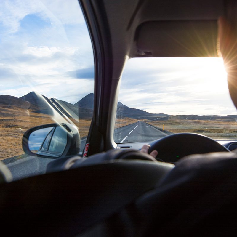 An over-the-shoulder view of a man driving the Ring Road.