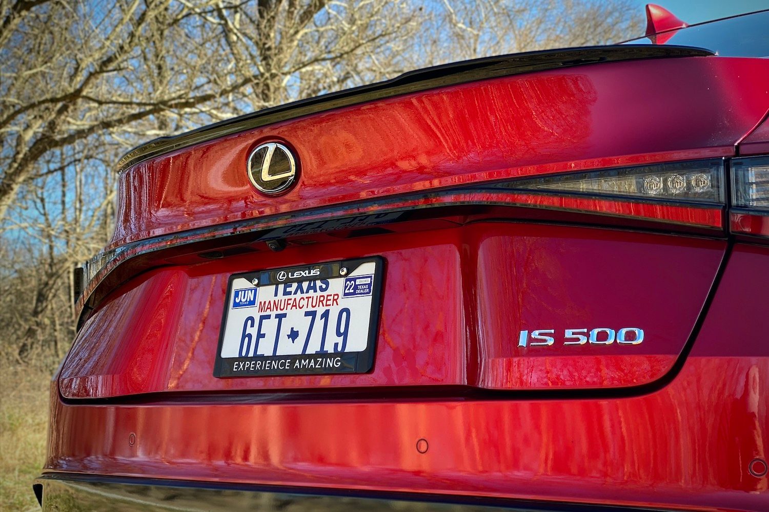 Close up of Lexus IS 500 rear trunk in front of trees.