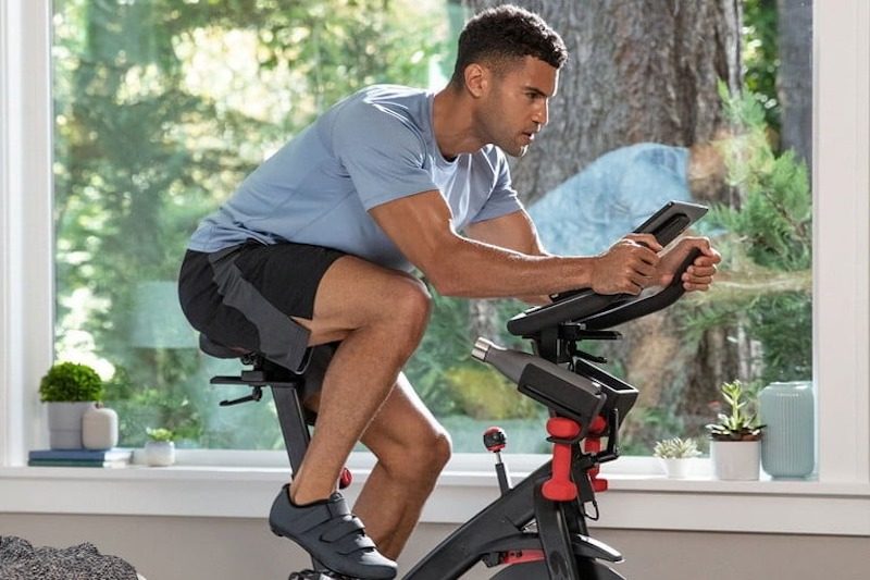Man using indoor cycling machine.
