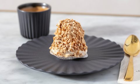 Merveilleux pastry on a plate next to a golden spoon.