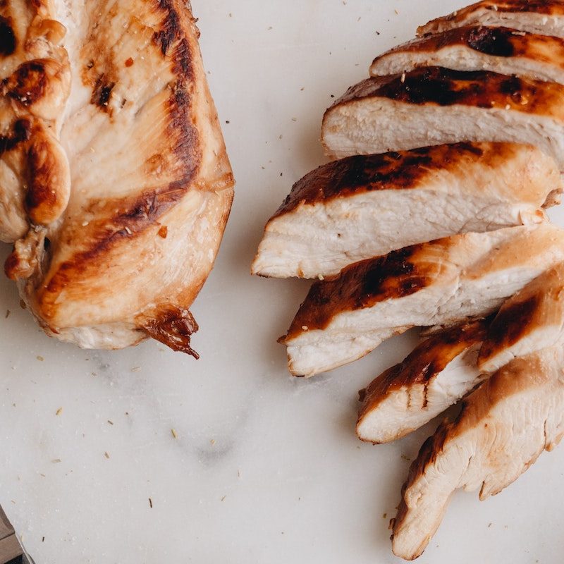 grilled chicken breast next to sliced chicken breast.