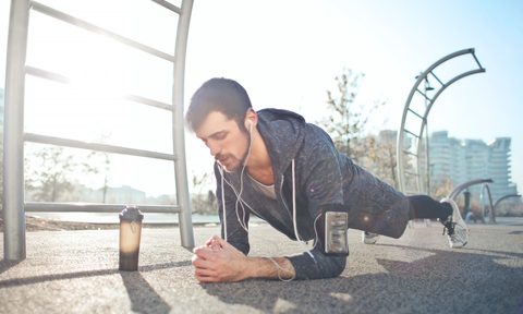 Man doing plank with pre-workout supplement