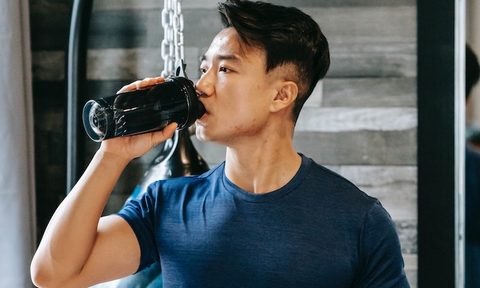 Man drinking pre-workout supplement.
