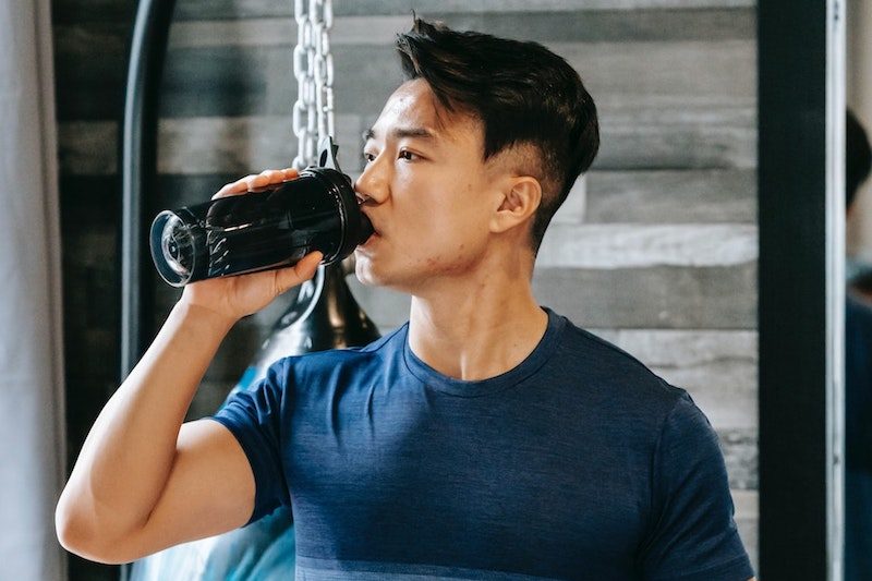 Man drinking pre-workout supplement.