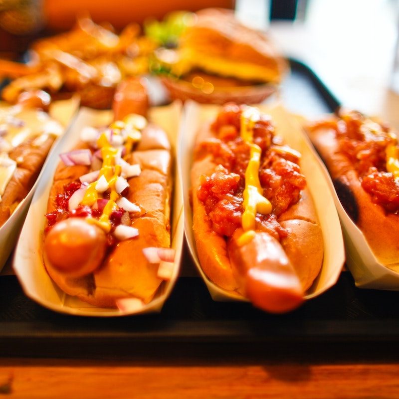 loaded hot dogs in buns on a tray.