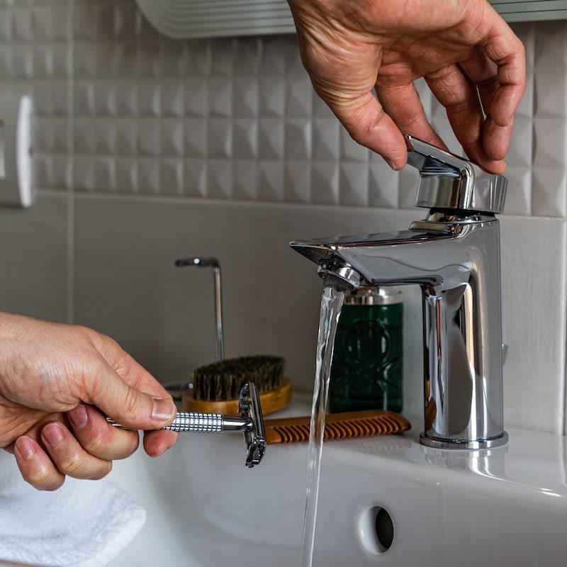Razor being rinsed under water.