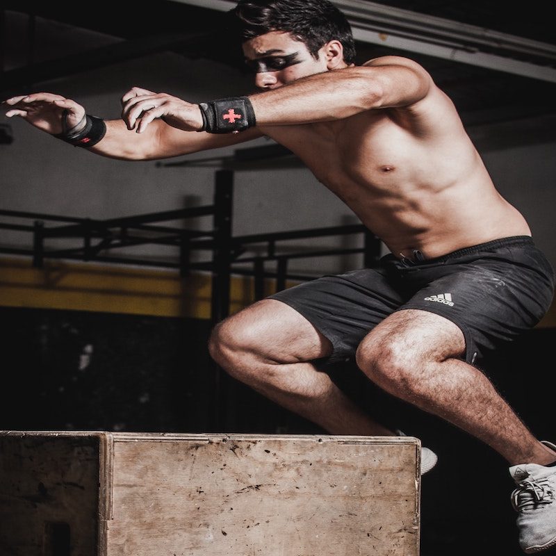 man doing plyometric box jump.