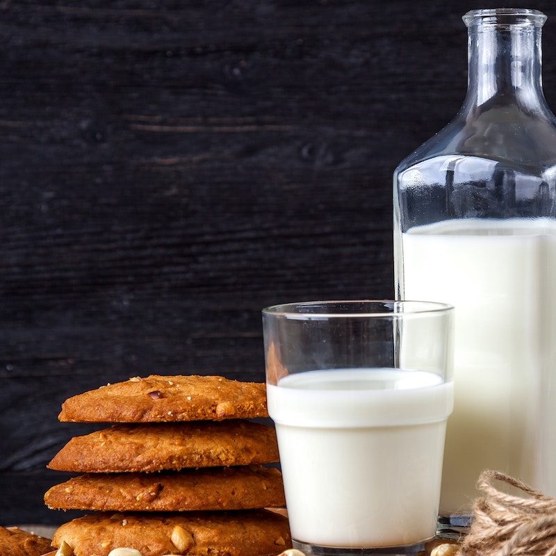 cream in a glass jar next to cream in a glass next to a stack of cookies.