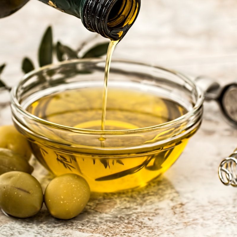Olive oil being poured into a bowl.