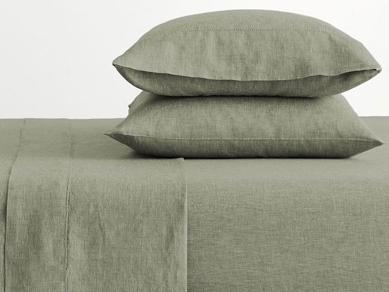 Pillows on a bed with linen sheet from Pottery Barn.