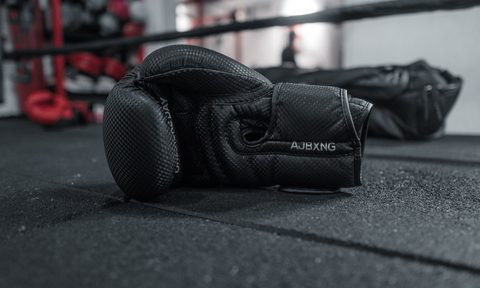 Boxing gloves sitting on the floor of the boxing ring.