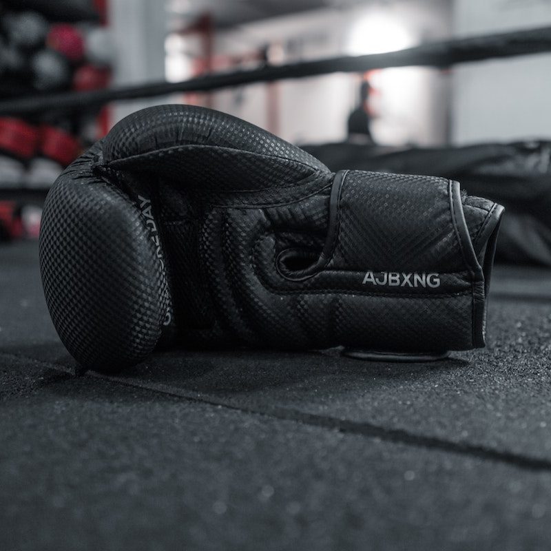 Boxing gloves sitting on the floor of the boxing ring.