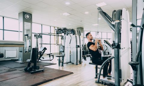 Man doing lat pull-downs in the gym