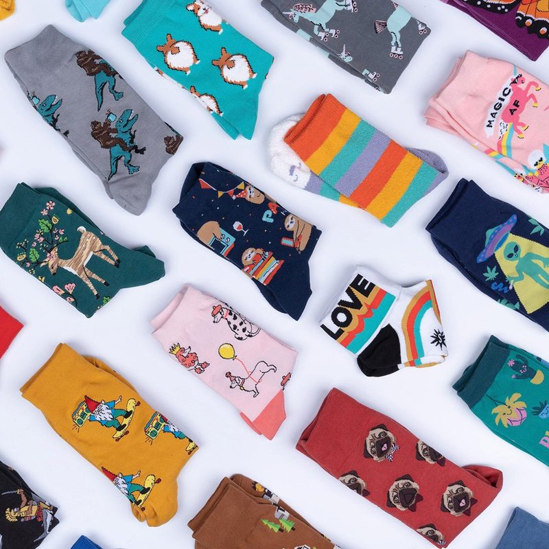 Socks with fun prints arranged neatly on a surface.