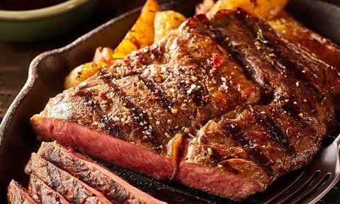 A close-up of grilled meat on a plate.