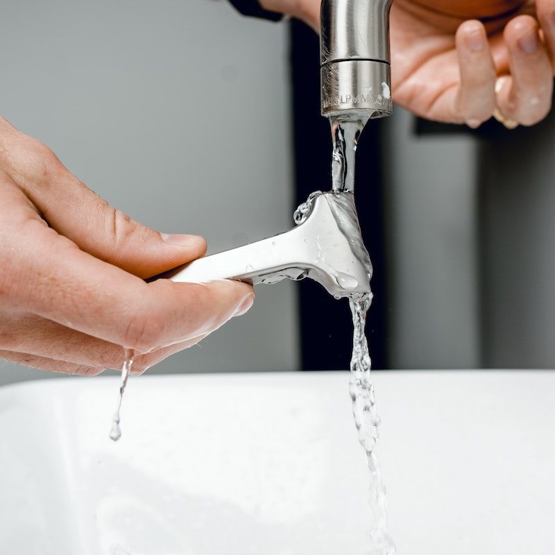 Rinsing off a razor in a sink.