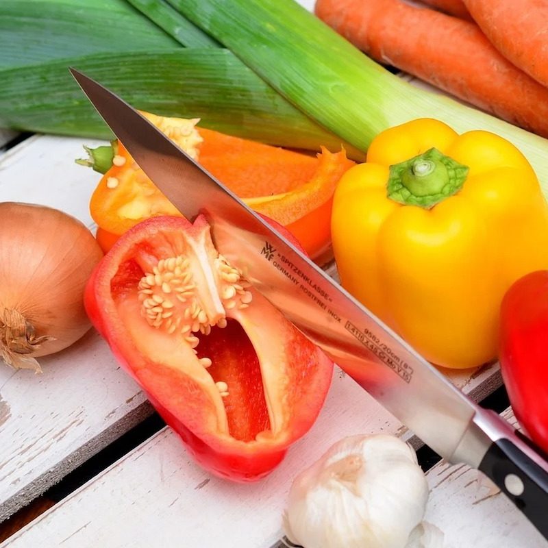 vegetables sitting on a table with a knife.