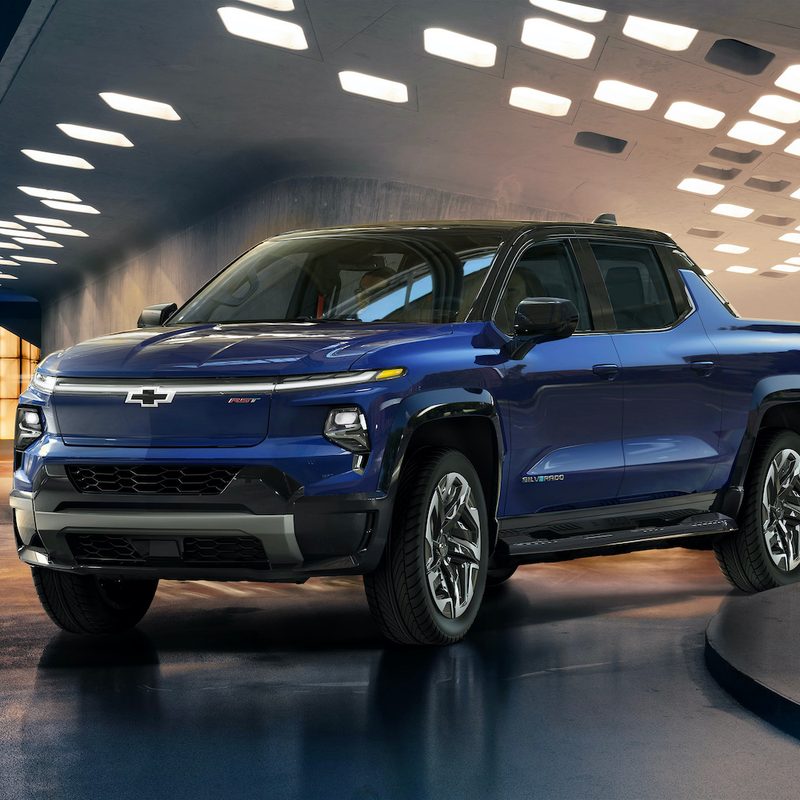 2024 Chevrolet Silverado EV RST in front of lights on a wet street.
