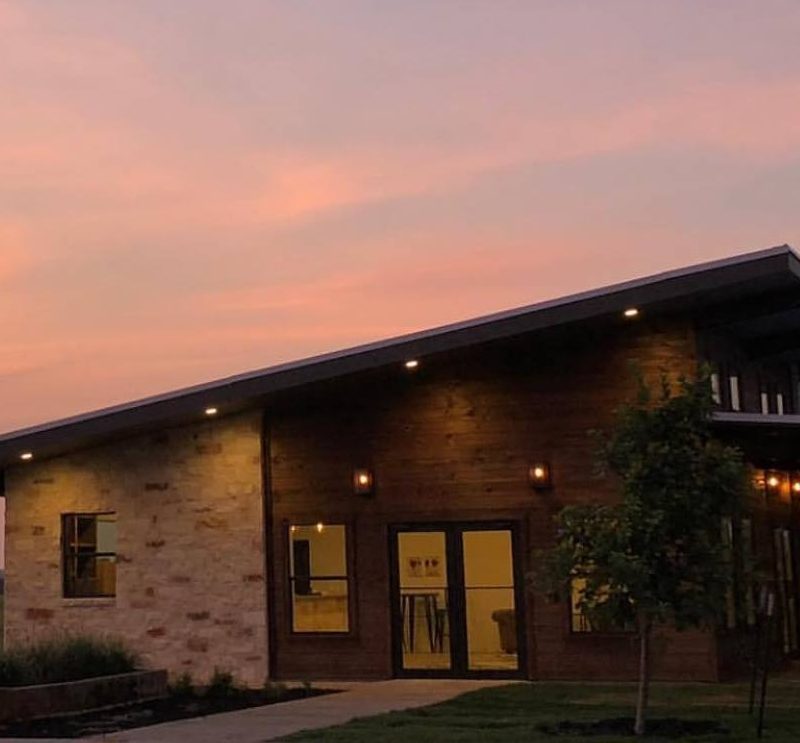 A photo of the AB Astris Winery against a sunset.