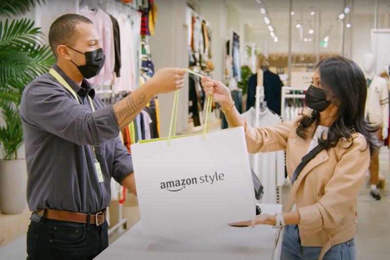 An Amazon Style clerk hands over a purchase to a customer.